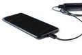 Black mobile phone and charger isolated on white background.Copy space Royalty Free Stock Photo