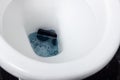 Black mobile phone falling into toilet water