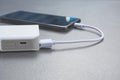 Mobile smart phones charging with power bank on desk.