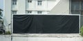 Black mock up billboard on fence on blur city background