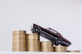 A black model of a car with coins in the form of a histogram on a white background. Concept of lending, savings, insurance Royalty Free Stock Photo