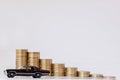 A black model of a car with coins in the form of a histogram on a white background. Concept of lending, savings, insurance Royalty Free Stock Photo