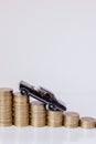 A black model of a car with coins in the form of a histogram on a white background. Concept of lending, savings, insurance