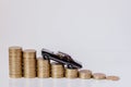 A black model of a car with coins in the form of a histogram on a white background. Concept of lending, savings, insurance Royalty Free Stock Photo