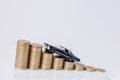 A black model of a car with coins in the form of a histogram on a white background. Concept of lending, savings, insurance