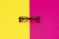 Black modern eye glasses on red and yellow background Royalty Free Stock Photo