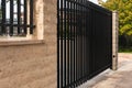 Black modern gate. Black metal garden entrance gates set in brick fence Royalty Free Stock Photo