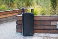 black modern trash bin in the park. Royalty Free Stock Photo