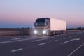 A black modern truck wagon transports cargo in a trailer refrigerator at night. Concept logistics and online stock exchange for