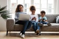 Black mom and kids using laptop phones addicted to devices Royalty Free Stock Photo