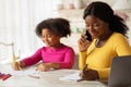 Black Mom Working In Kitchen While Her Daughter Drawing Next To Her Royalty Free Stock Photo