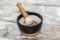 Black mortar with ground pepper and pestle on marble kitchen countertop Royalty Free Stock Photo