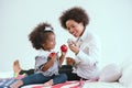 Black mother and daughter playfully play with toys in the bedroom of the house