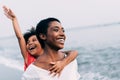 Black mother and daughter running on the beach at sunset time during summer vacation - Family people having fun together outdoor Royalty Free Stock Photo