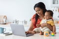 Black Mother Taking Care About Baby And Working On Laptop At Home Royalty Free Stock Photo