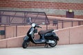 Black motor scooter parked with kick stand