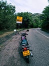 a motorcycle parked on the side of the road with an upside down sign