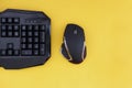 Black mouse, keyboard isolated on a yellow background, top view. Flat lay gamer background Royalty Free Stock Photo
