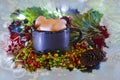 Black mug filled with marshmallow on the background of Christmas decorations and spruce branches. The effect of frozen glass. Chri