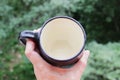 Black mug made of clay. decor - covering with black engobe and transparent glaze. two firing. made on a potter`s wheel. handmade