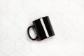 Black mug on a white hexagon tiled kitchen countertop Royalty Free Stock Photo