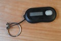 A black security token dongle rests on a wood surface with a metal keyring attached, used for multi-factor authentication and Royalty Free Stock Photo