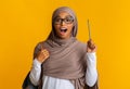 Black muslim girl in hijab and eyeglasses raising pencil, having idea