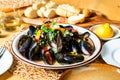 Black mussels, fork, bread and lemon on table Royalty Free Stock Photo