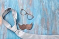 Black mustache, glasses and tie on color wooden background. Happy Father's Day celebration