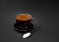 Black, natural, fragrant coffee in the transparent cup on a black background. Hot drink.