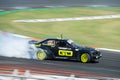 Black and neon green BMW E36 producing smoke on a trail for a drift competition