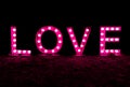 Black night with the word and text love written in brightly lit letters in pink