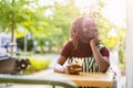 Black non-binary person sitting in an outdoor cafe