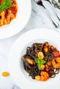 black noodles with mussels, shrimp, tomatoes and herbs top view Royalty Free Stock Photo