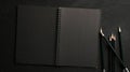 Black notebook with black papers and pencils on study table