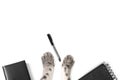 Black notebook and pen, smartphone, white laptop, gray cat paws on a white background. Royalty Free Stock Photo