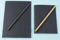 Black notebooks and pencils on blue background. Royalty Free Stock Photo