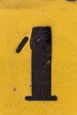 Black number stencil painted on yellow background