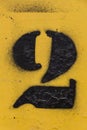 Black number stencil painted on yellow background