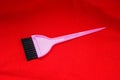 Black nylon bristle hair dye brush with pink handle on red background Royalty Free Stock Photo