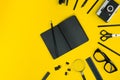 Black objects from the office on a yellow background. Work and creativity. Top view.