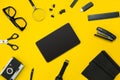Black objects from the office on a yellow background. Work and creativity. Top view. Royalty Free Stock Photo