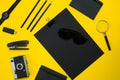 Black objects from the office on a yellow background. Work and creativity. Top view. Royalty Free Stock Photo