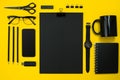 Black objects from the office on a yellow background. Work and creativity. Top view. Royalty Free Stock Photo