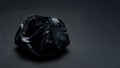 Black obsidian volcanic rock on dark background Royalty Free Stock Photo