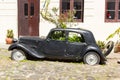 Black and obsolete car on one of the cobblestone streets, in the city of Colonia del Sacramento, Uruguay. It is one of the oldest Royalty Free Stock Photo