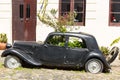 Black and obsolete car on one of the cobblestone streets, in the city of Colonia del Sacramento, Uruguay. It is one of the oldest Royalty Free Stock Photo