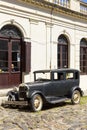 Black and obsolete car on one of the cobblestone streets, in the city of Colonia del Sacramento, Uruguay. It is one of the oldest Royalty Free Stock Photo