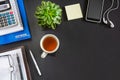 Black office desk with notebook, calculator, diary and smartphone with headphones. Top view with copy space, flat lay Royalty Free Stock Photo