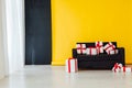 Office sofa with red gifts in the interior of the room with a yellow background Royalty Free Stock Photo
